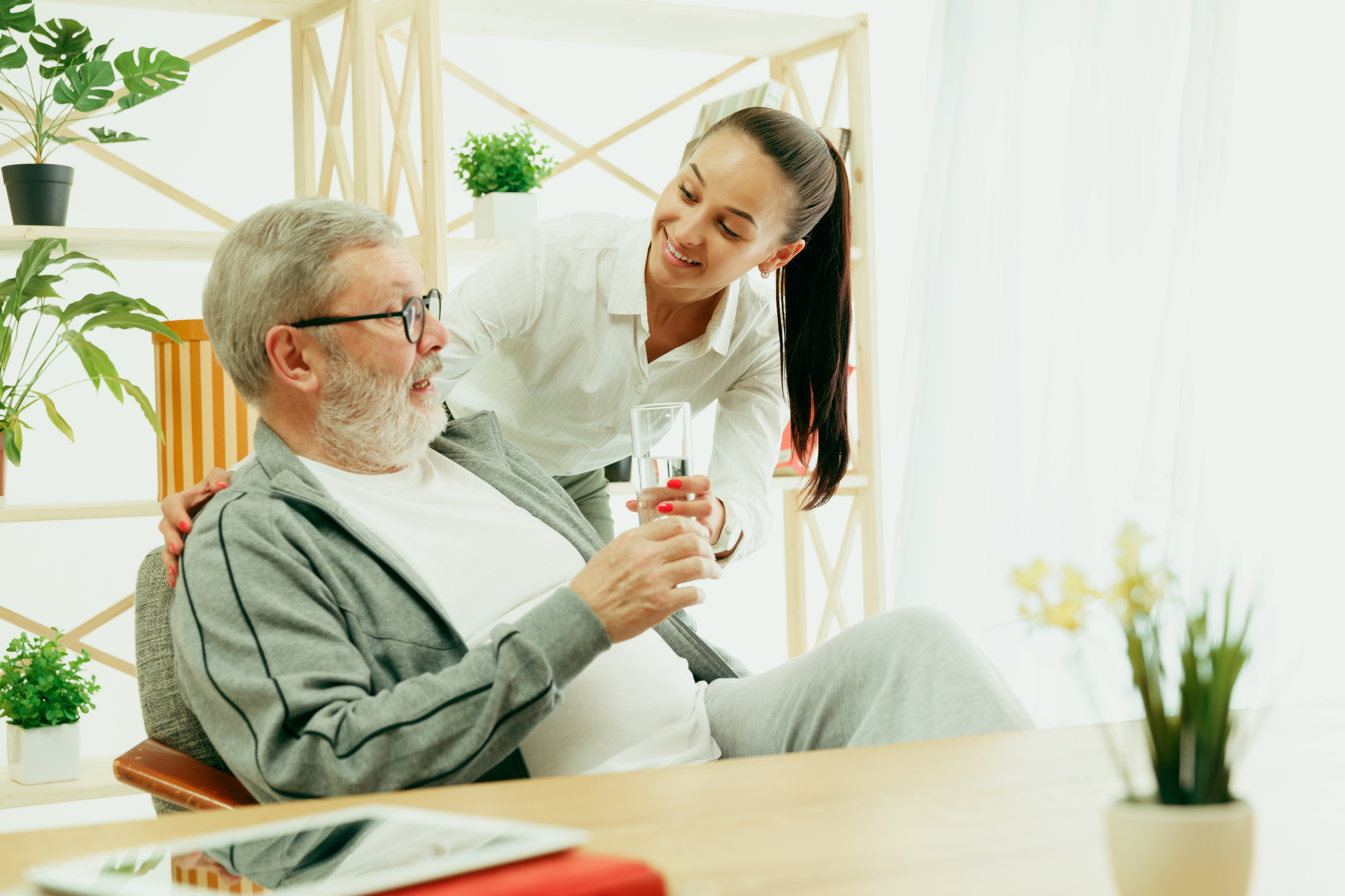A daughter or granddaughter spends time with the grandfather