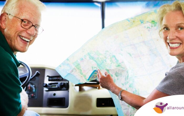 An older couple looks back smiling from the front of an RV, representing how day trips for seniors can help boost the mood of everyone.