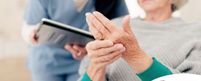 A caregiver provides in home care services to a senior with arthritis