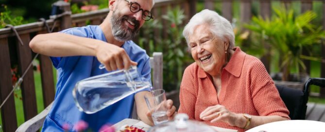 A caregiver applies summer Caregiving Tips including helping a senior stay hydrated.